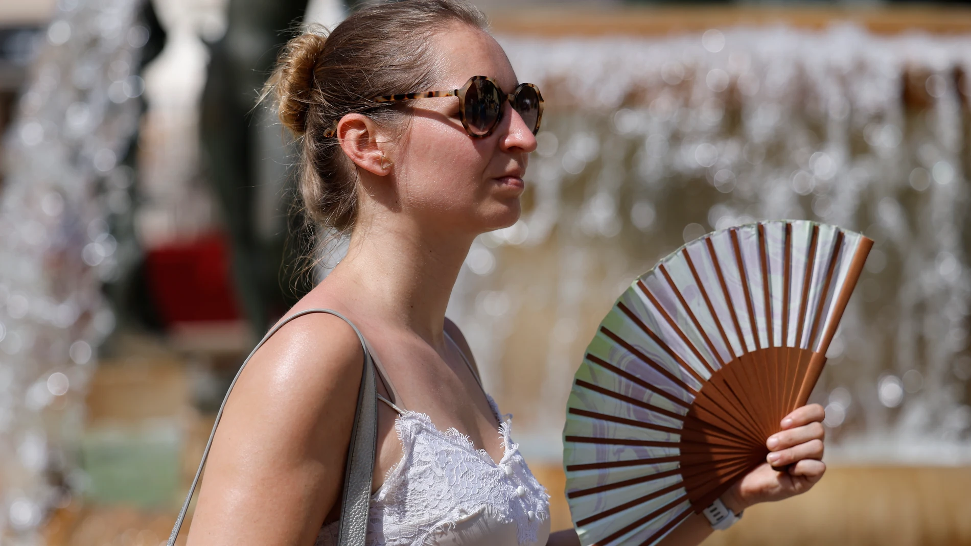 Una viandante se abanica para combatir el calor