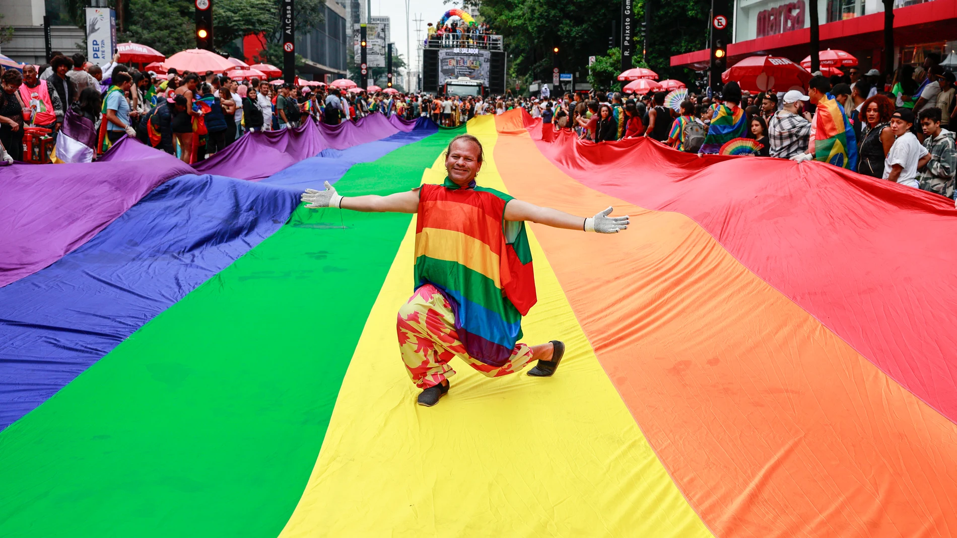 AME7783. SAO PAULO (BRASIL), 22/06/2025.- Una persona posa sobre una bandera durante la Marcha del Orgullo este domingo, en la avenida Paulista de Sao Paulo (Brasil). EFE/ Sebastiao Moreira