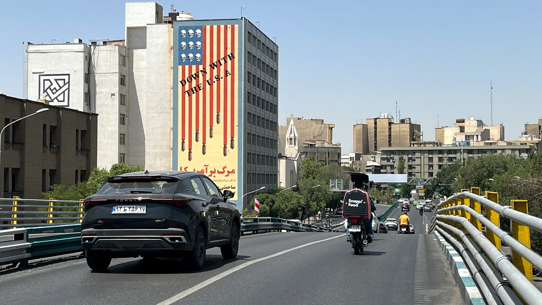 Tehran (Iran (Islamic Republic Of)), 22/06/2025.- Traffic passes by a building displaying an anti-US mural in Tehran, Iran, 22 June 2025. The US forces struck three of Iran's key nuclear sites: Natanz, Isfahan and Fordo, US President Trump announced on 21 June. Israel and Iran have been exchanging fire since Israel launched strikes across Iran on 13 June 2025 as part of Operation 'Rising Lion.' (Teherán) EFE/EPA/ABEDIN TAHERKENAREH