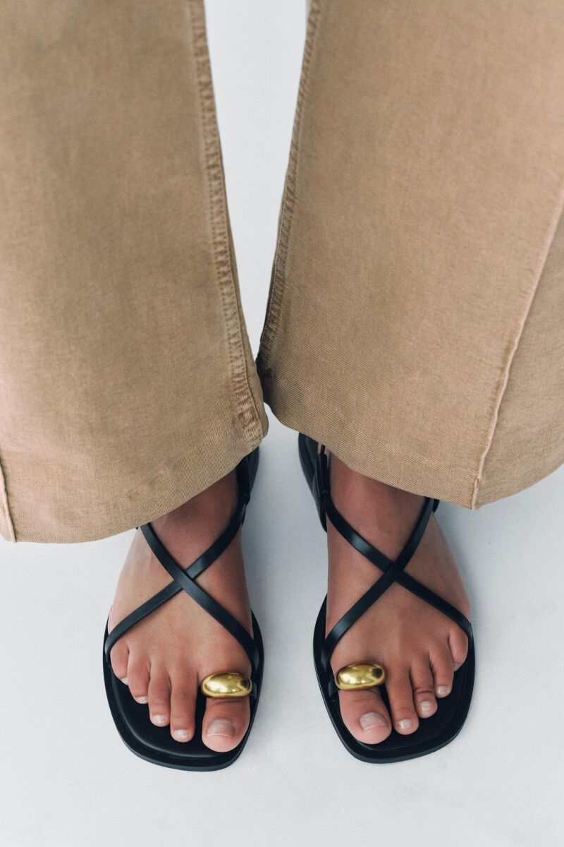 Sandalias negras con detalle dorado en el dedo