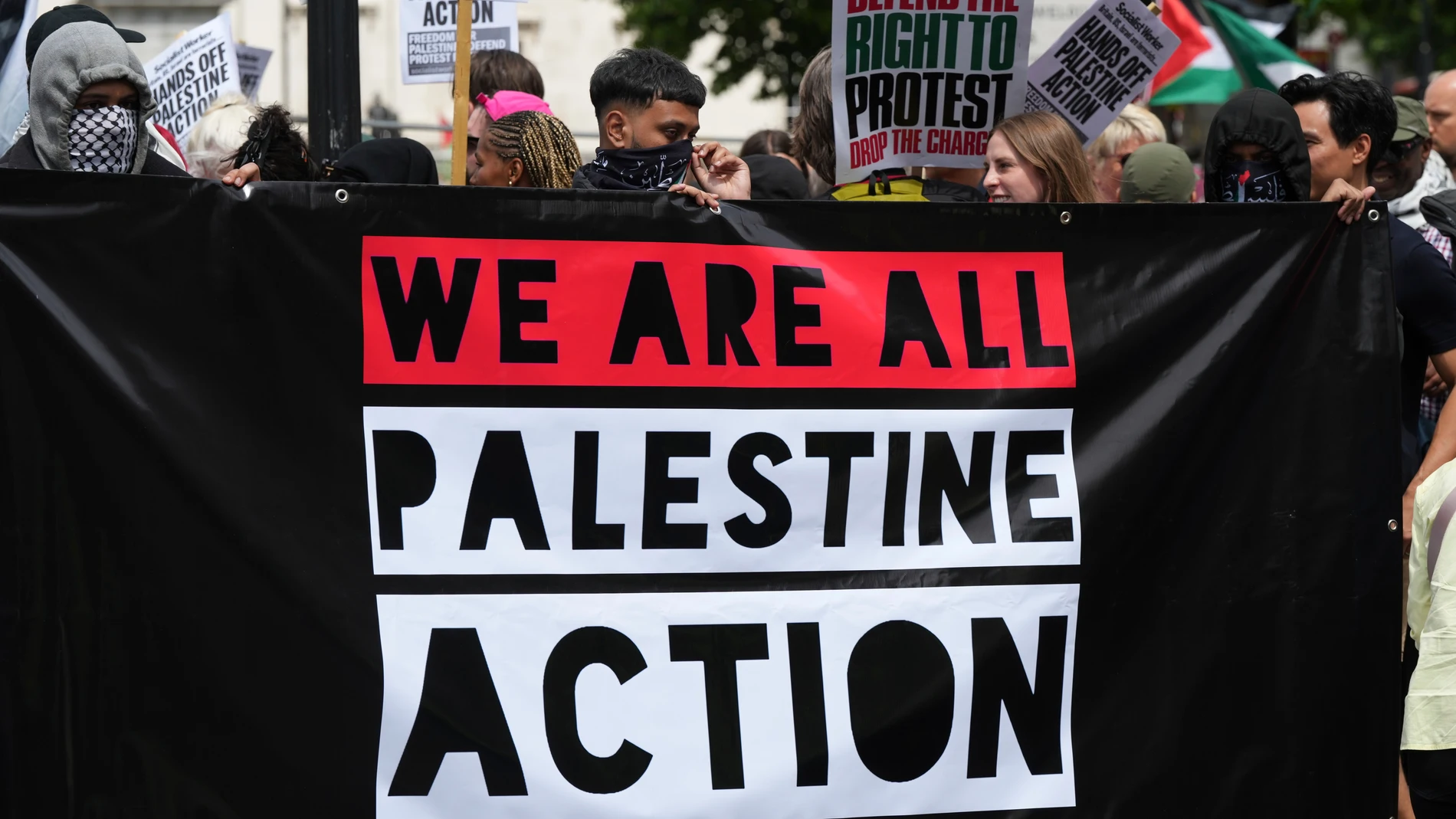 Demonstrators hold up a banner during a protest by Palestine Action group in London, Monday, June 23, 2025. (AP Photo/Frank Augstein)