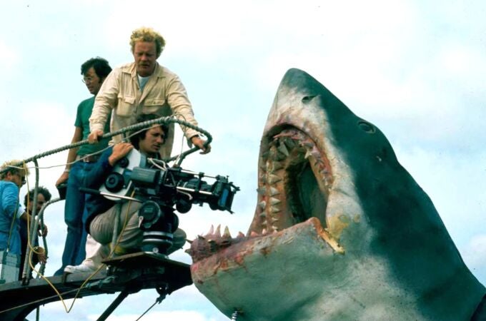 Fotografía cedida por la Academia de Cine donde aparece el director Steven Spielberg (c-abajo), mientras captura un plano del tiburón mecánico 'Bruce', durante el rodaje de la película 'Tiburón', en la isla Martha's Vineyard, en Massachusetts (EE.UU). El desembarco de Spielberg para realizar el rodaje de 'Tiburón', cambió la isla para siempre y con ella, la taquilla internacional. El filme, estrenado el 20 de junio de 1975, hace justo medio siglo, instigó además un miedo colectivo a bañarse en el mar. 