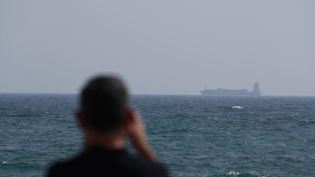 Una persona mira el tránsito de un barco por el estrecho de Ormuz