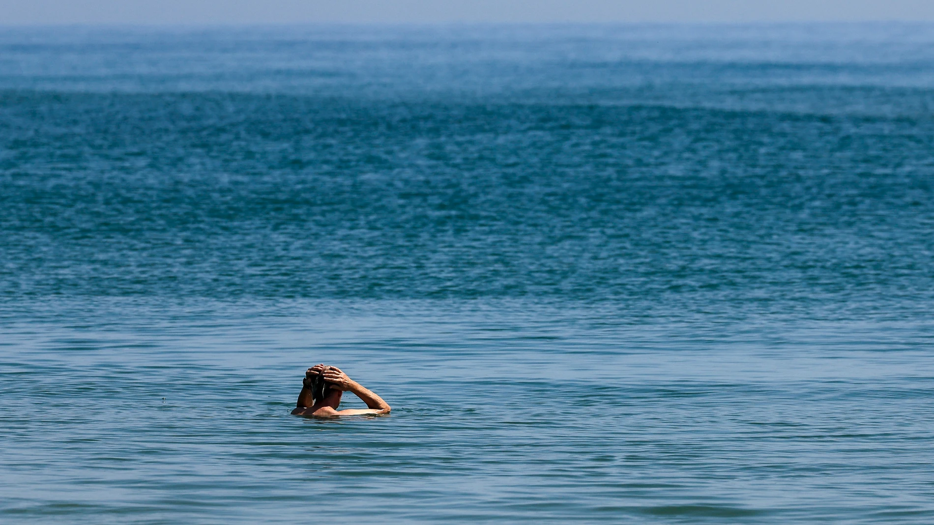 VALENCIA, 25/06/2025.- Uno hombre toma un baño en la playa de El Saller de Valencia, este miércoles. EFE/Kai Forsterling