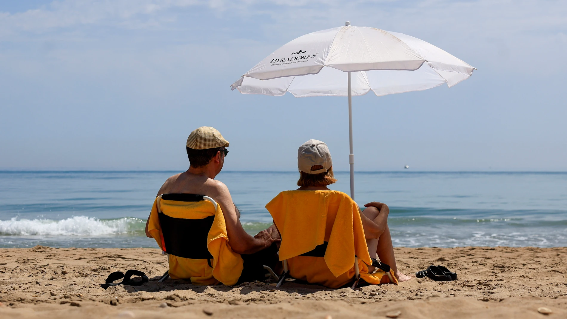 VALENCIA, 25/06/2025.- Dos personas disfrutan de un día de playa en El Saller, Valencia, este miércoles. EFE/Kai Forsterling