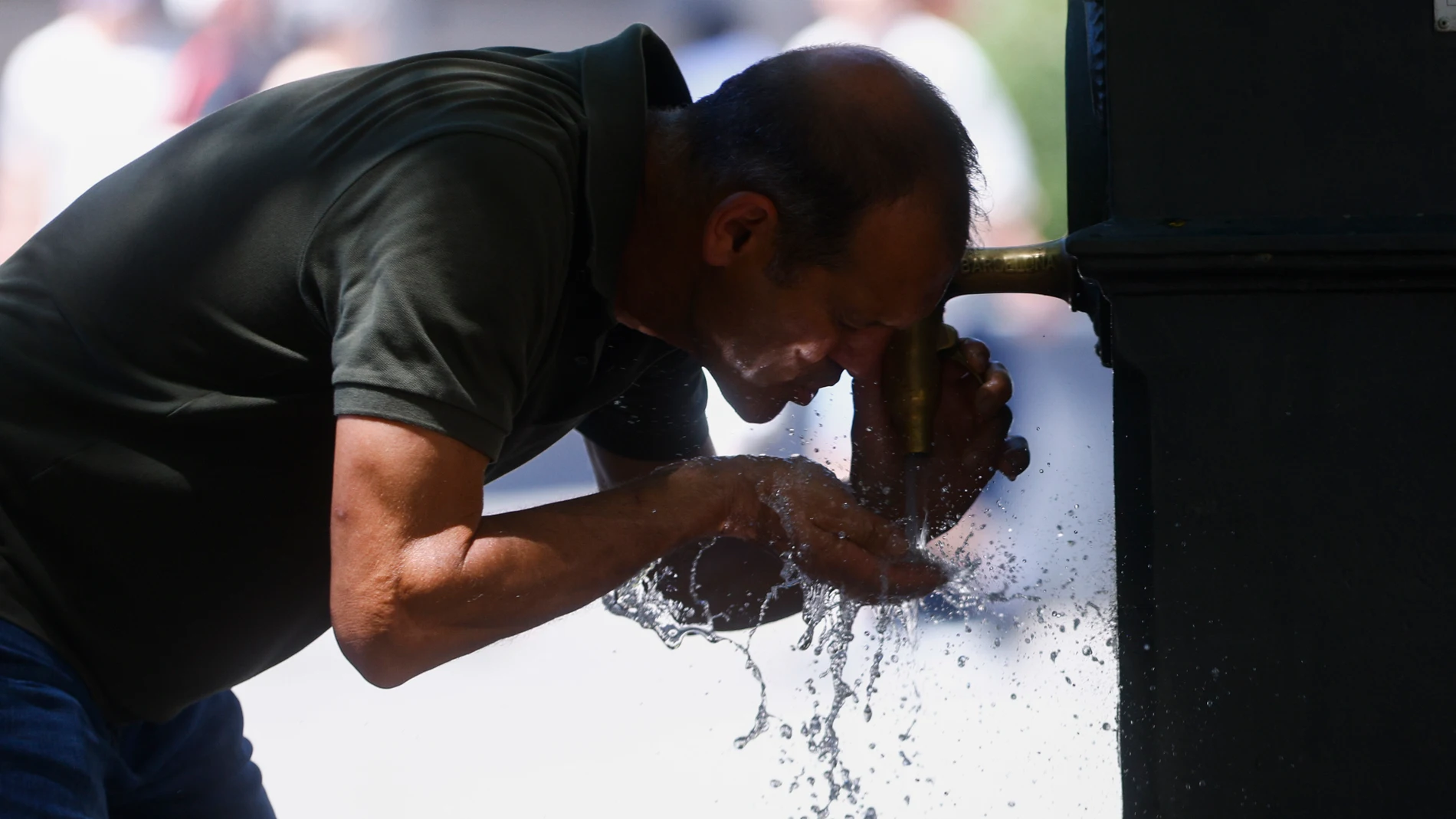BARCELONA, 28/06/2025.- Un hombre se refresca en una fuente en Barcelona este sábado. Catorce comunidades están este sábado en alerta por temperaturas excepcionalmente altas en el día de inicio de la primera ola de calor del verano en España. EFE/Quique García