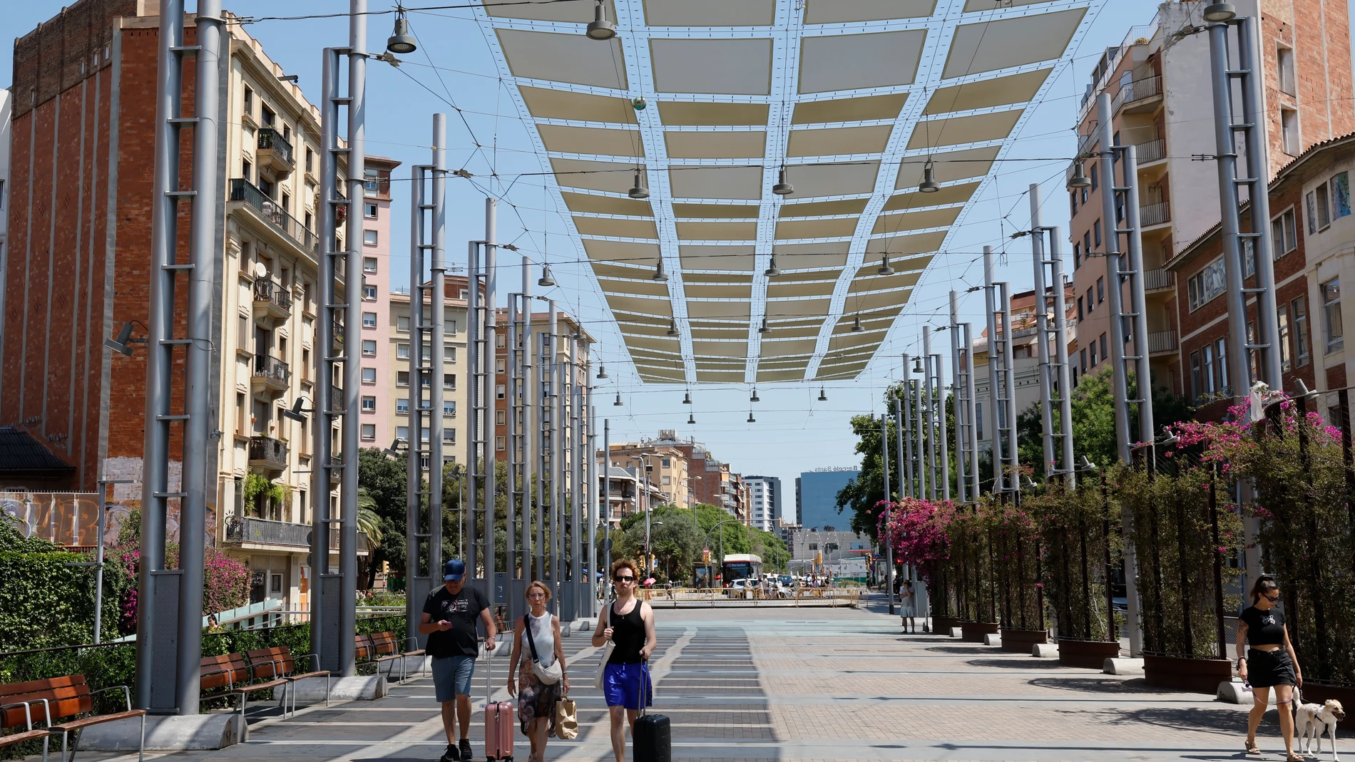 BARCELONA, 29/06/2025.- Unas personas transitan a la sombra de un umbráculo en la Rambla de Sants en Barcelona este domingo. Cataluña afronta este domingo el segundo día de la primera ola de calor de 2025, que en principio se prolongará hasta el martes, tras una noche tórrida que ha dejado una mínima de 30,4 grados en Portbou (Girona) y de 28 en Barcelona, según los registros del servicio Meteocat. Una ola de calor en la que ayer se registraron 46 grados en El Granado (Huelva), un hecho que n...