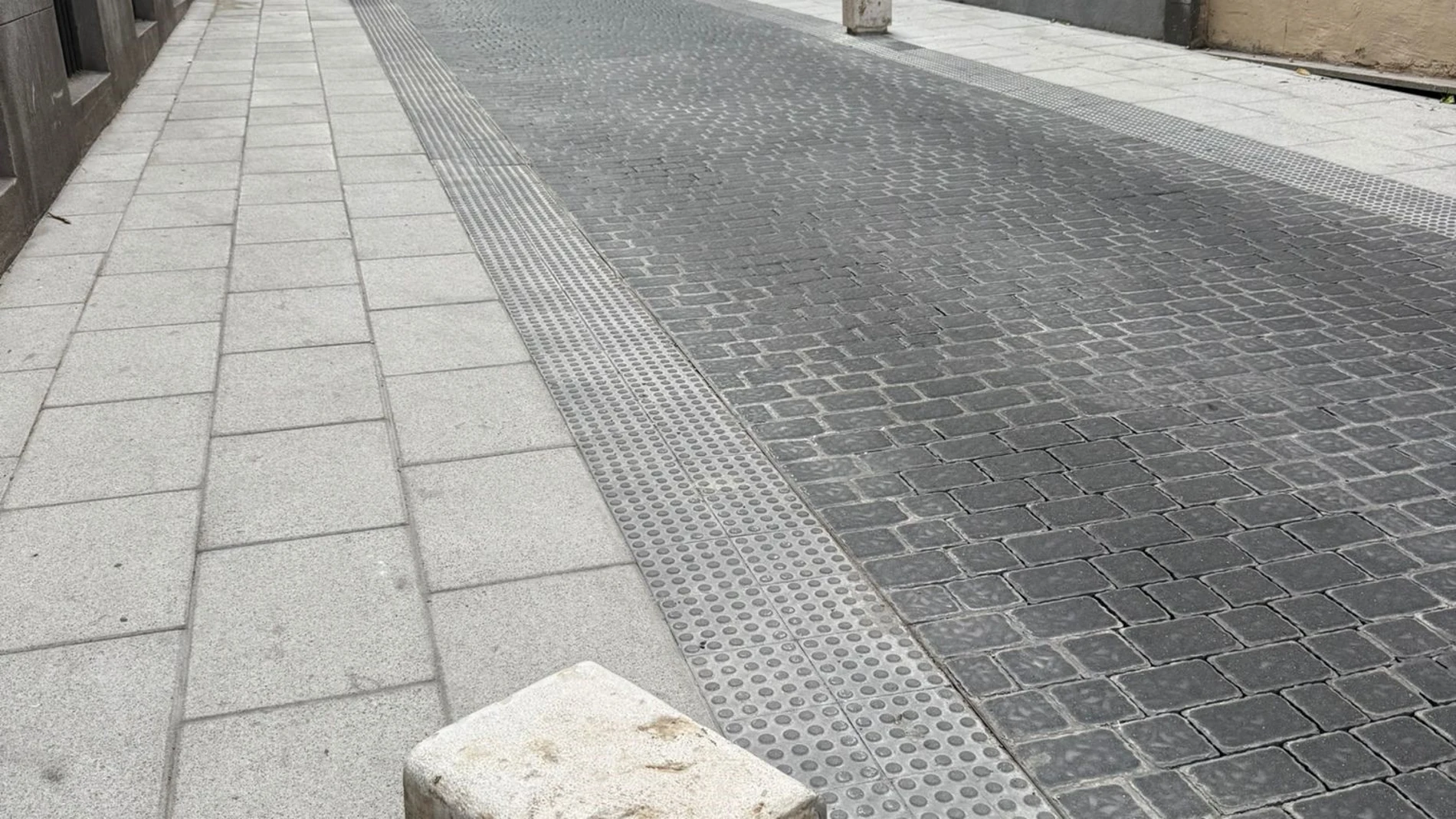 Un cubo caído en la calle San Hermenegildo tras el choque de un vehículo. EUROPA PRESS 27/06/2025
