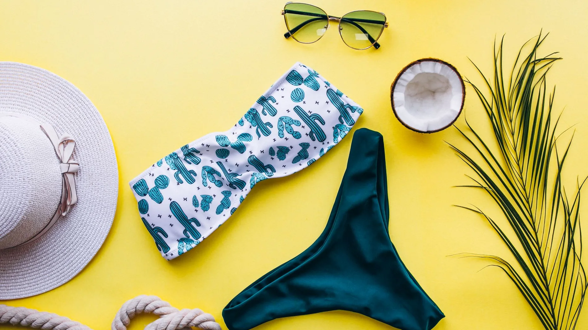 bikini sobre fondo amarillo con accesorios para la playa