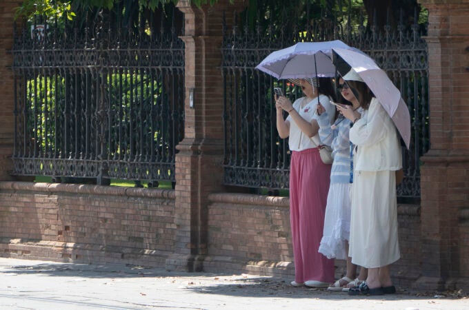 Varias mujeres se protegen del sol este domingo 