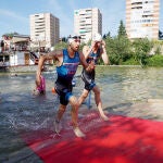 Varios triatletas salen del Pisuerga durante la competición en Valladolid