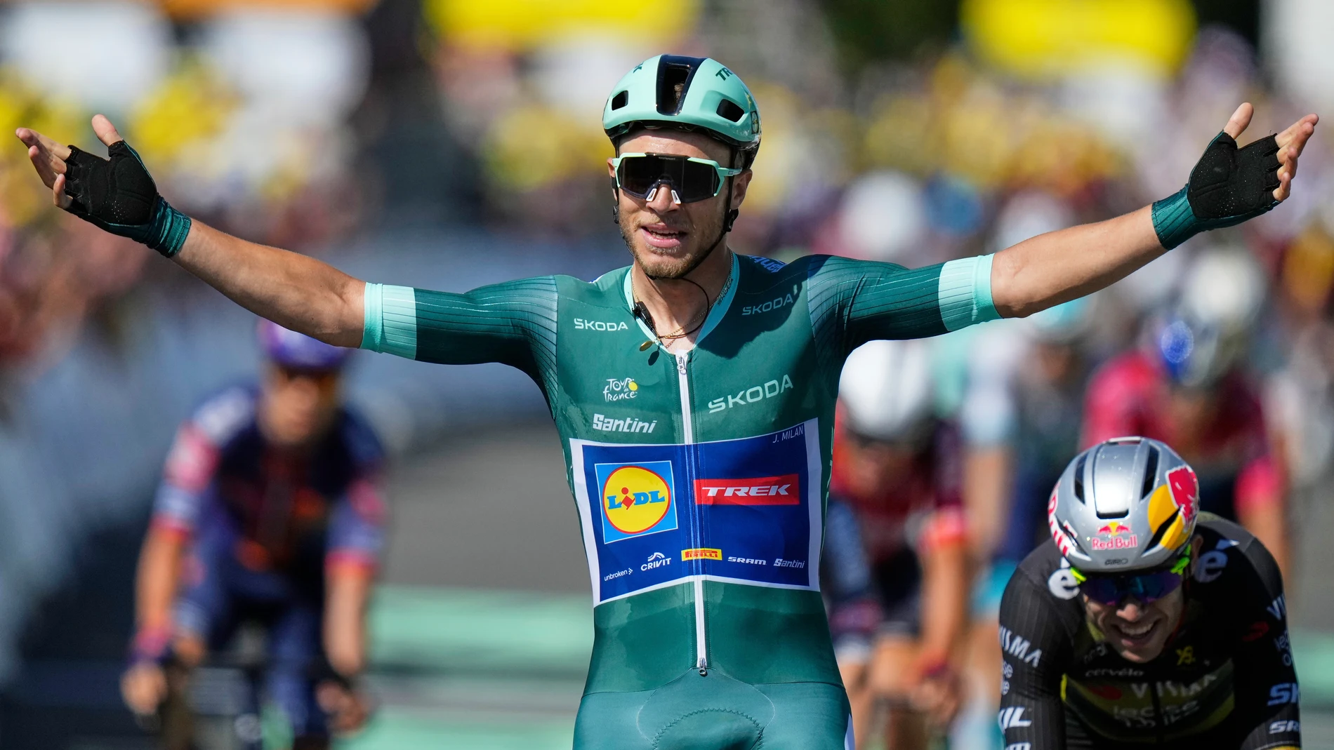Italy's Jonathan Milan crosses the finish line ahead of second placed Belgium's Wout van Aert, right, to win the eighth stage of the Tour de France cycling race over 171.4 kilometers (106.5 miles) with start in Saint-Meen-le-Grand and finish in Laval Espace Mayenne, France, Saturday, July 12, 2025. (AP Photo/Mosa'ab Elshamy)