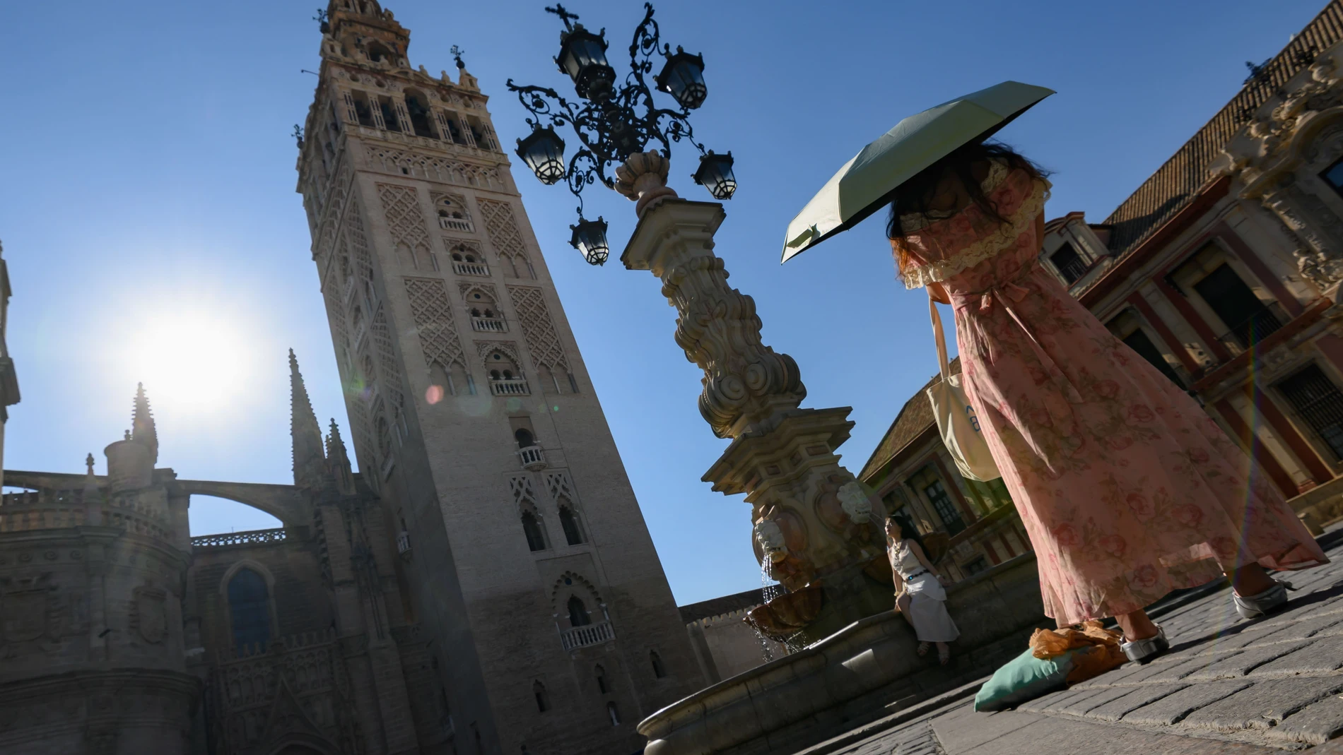 SEVILLA. 17/07/2025. - Turistas se toman fotos en los aledaños de la Catedral de Sevilla este jueves. La Agencia Estatal de Meteorología ha alertado de que este jueves de temperaturas significativamente altas, superiores a 40 grados en Córdoba, Granada, Jaén y Sevilla, y de 38 grados en Huelva. EFE/ Raúl Caro.