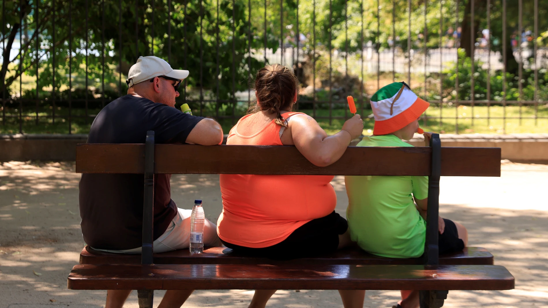 Una familia se refresca en un banco