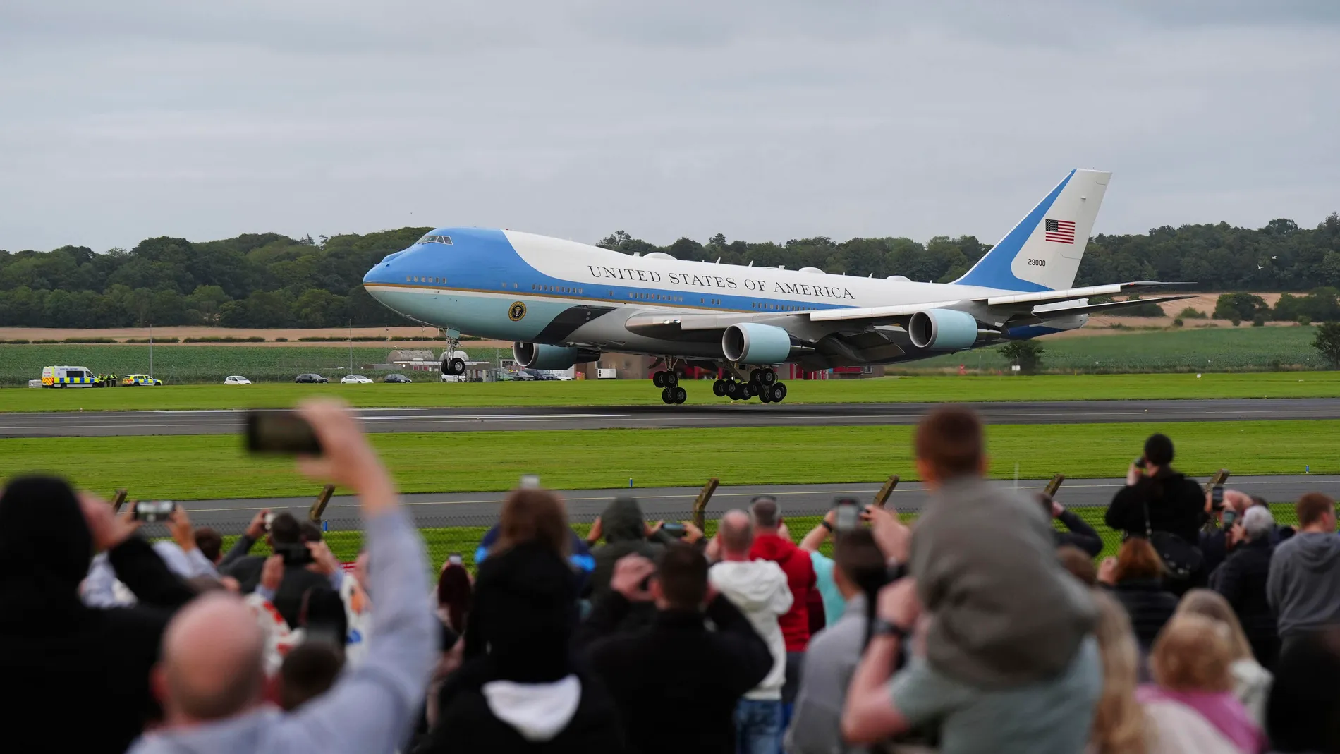 Trump supporters watch on as a plane carrying US President Donald Trump arrives at Prestwick Airport, as he begins his five-day private trip to the country, Friday July 25, 2025. (Jane Barlow/PA via AP)