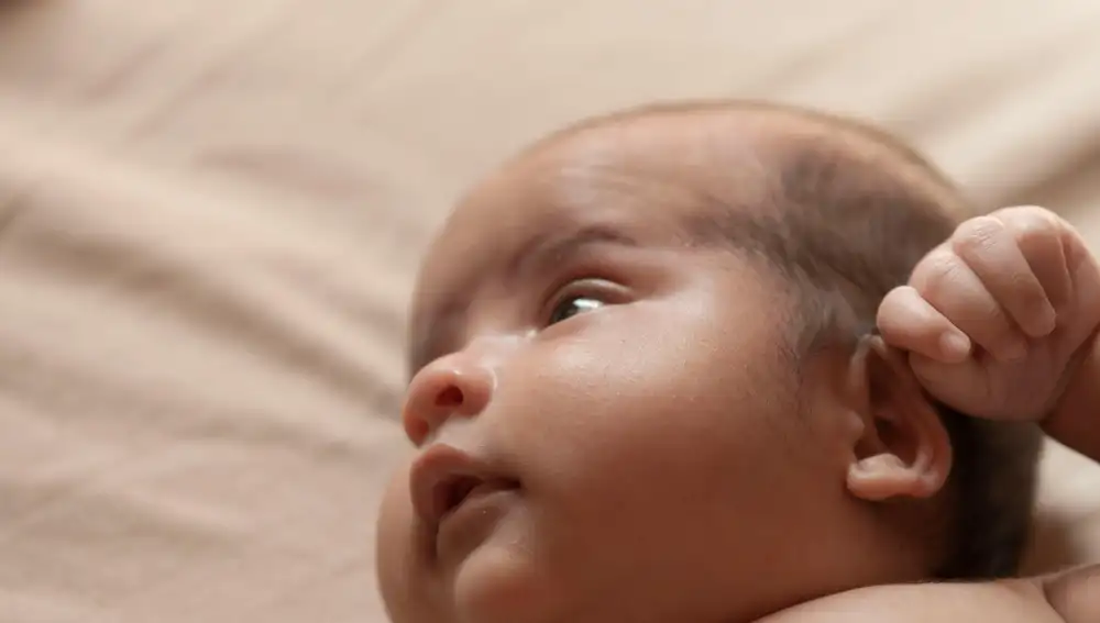 Bebé tocándose la oreja