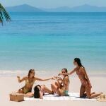 Influencers comiendo snacks en la playa.