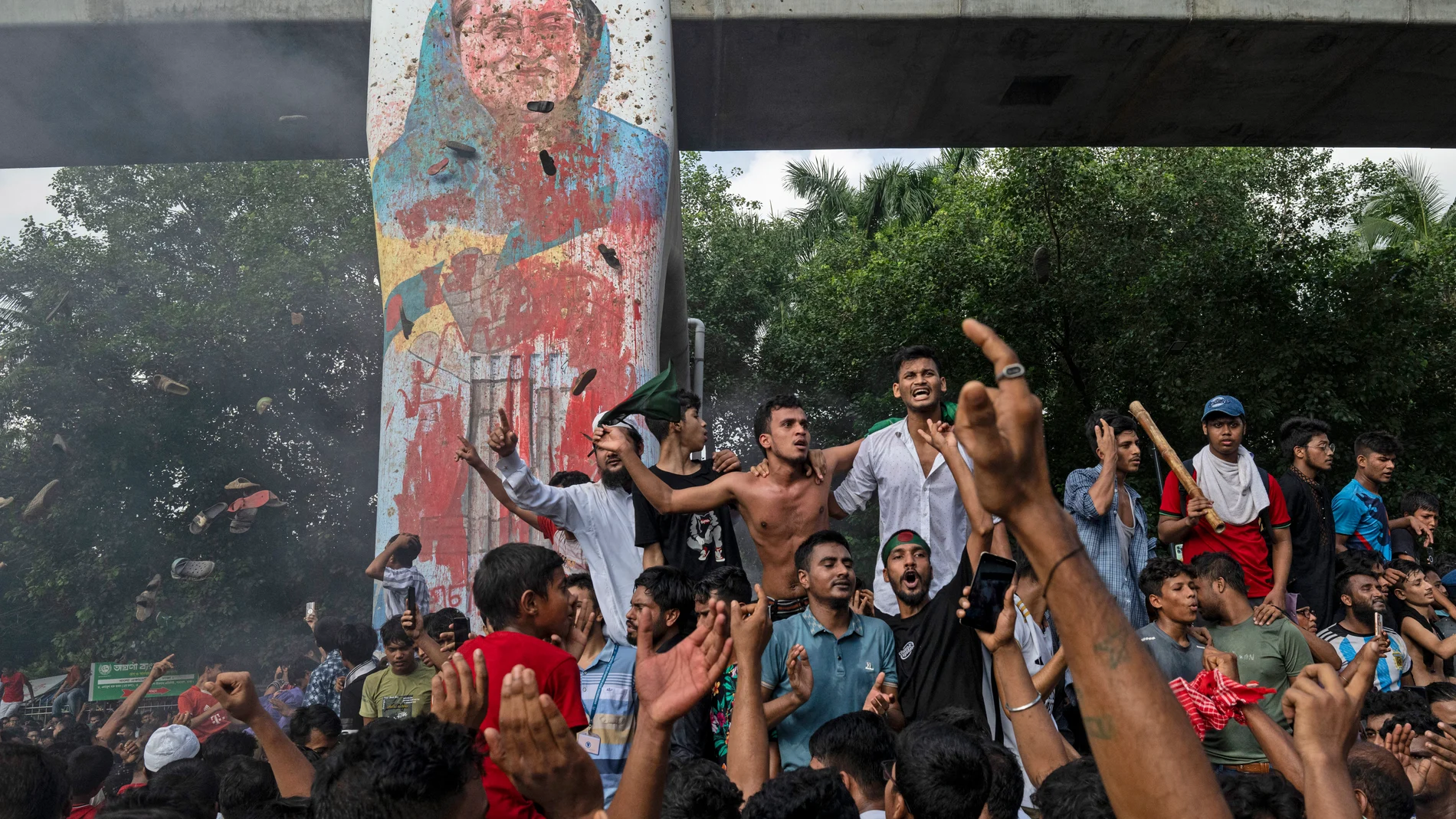 FILE- Protesters celebrate beside a defaced portrait of Prime Minister Sheikh Hasina after news of her resignation, in Dhaka, Bangladesh, Aug. 5, 2024. (AP Photo/Fatima Tuj Johora, File)