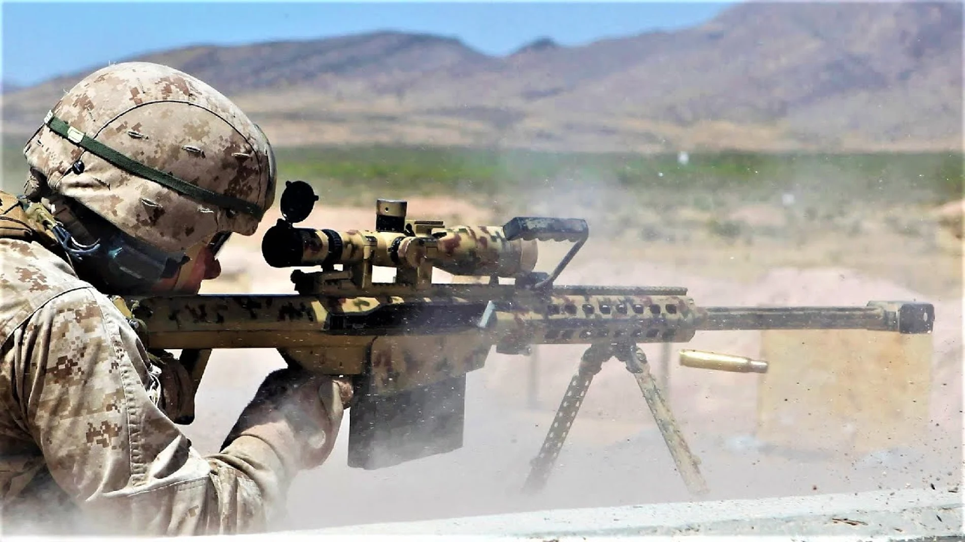 Aparece un soldado estadounidense utilizando un rifle de precisión durante unos ejercicios militares, él va vestido de camuflaje