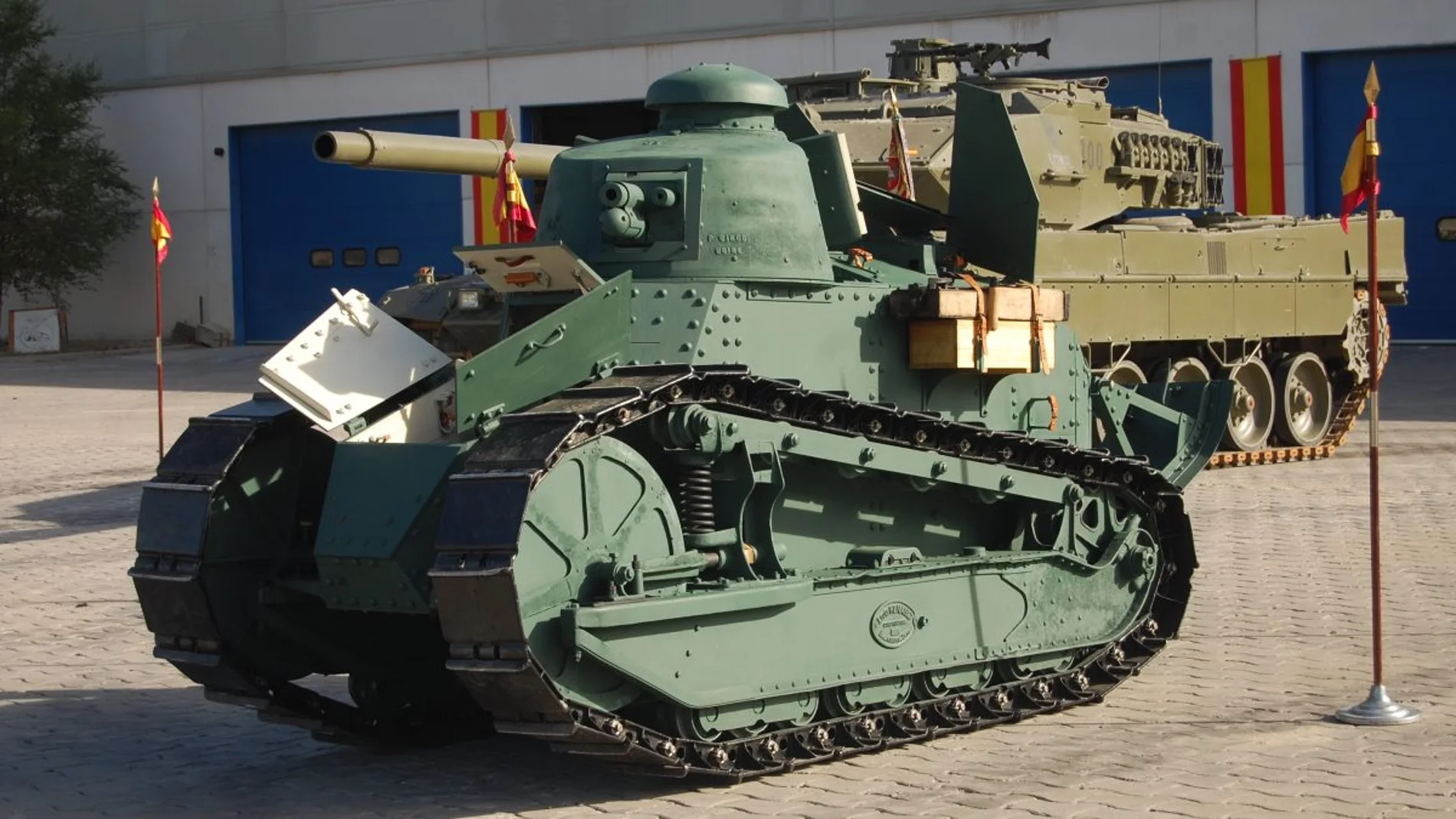 Aparece un carro de combate de color verde caqui delante de otro carro de combate moderno