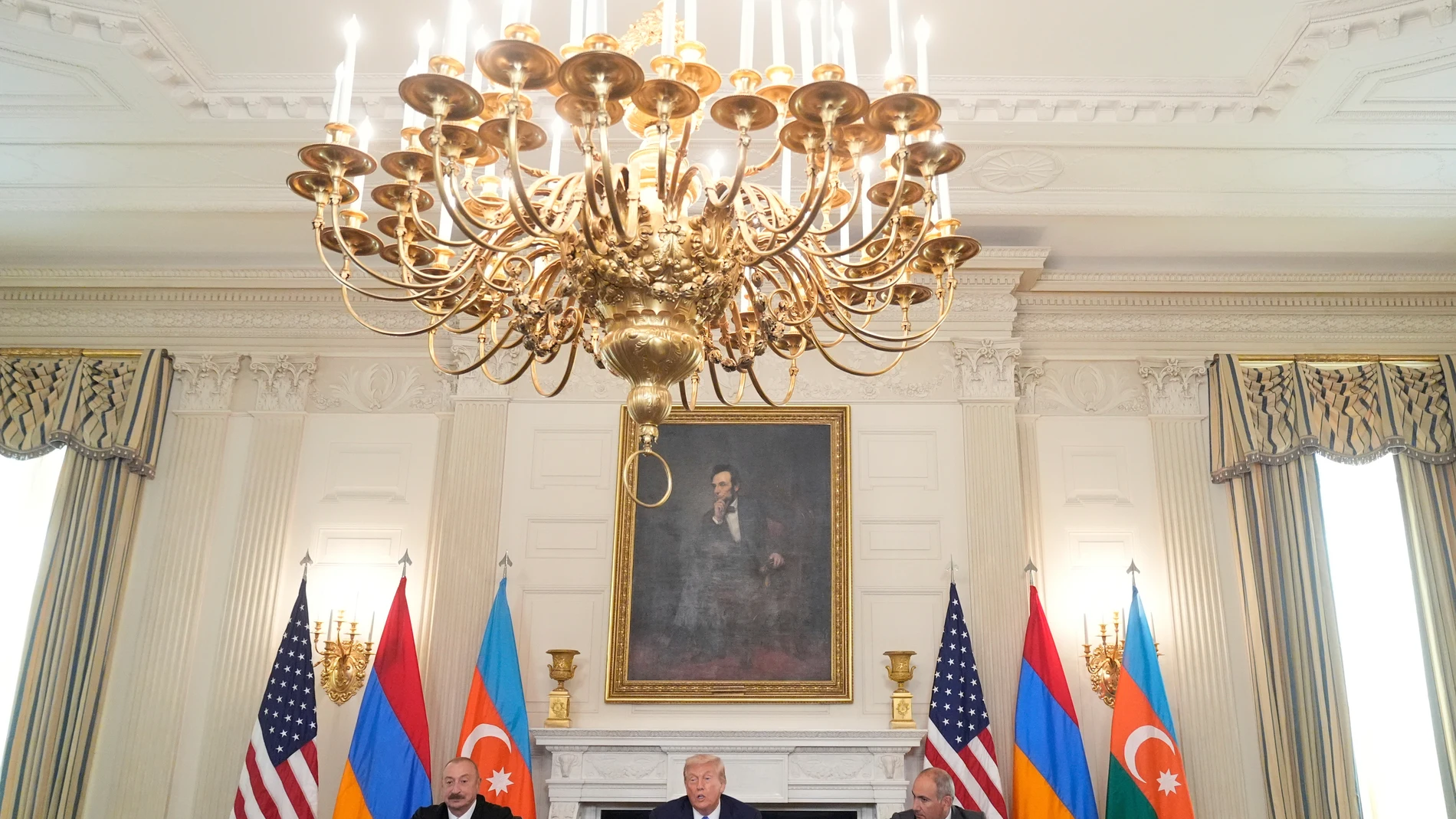 President Donald Trump, center, speaks during a trilateral signing with Azerbaijan's President Ilham Aliyev, left, and Armenia's Prime Minister Nikol Pashinyan in the State Dining Room of the White House, Friday, Aug. 8, 2025, in Washington. (AP Photo/Mark Schiefelbein)