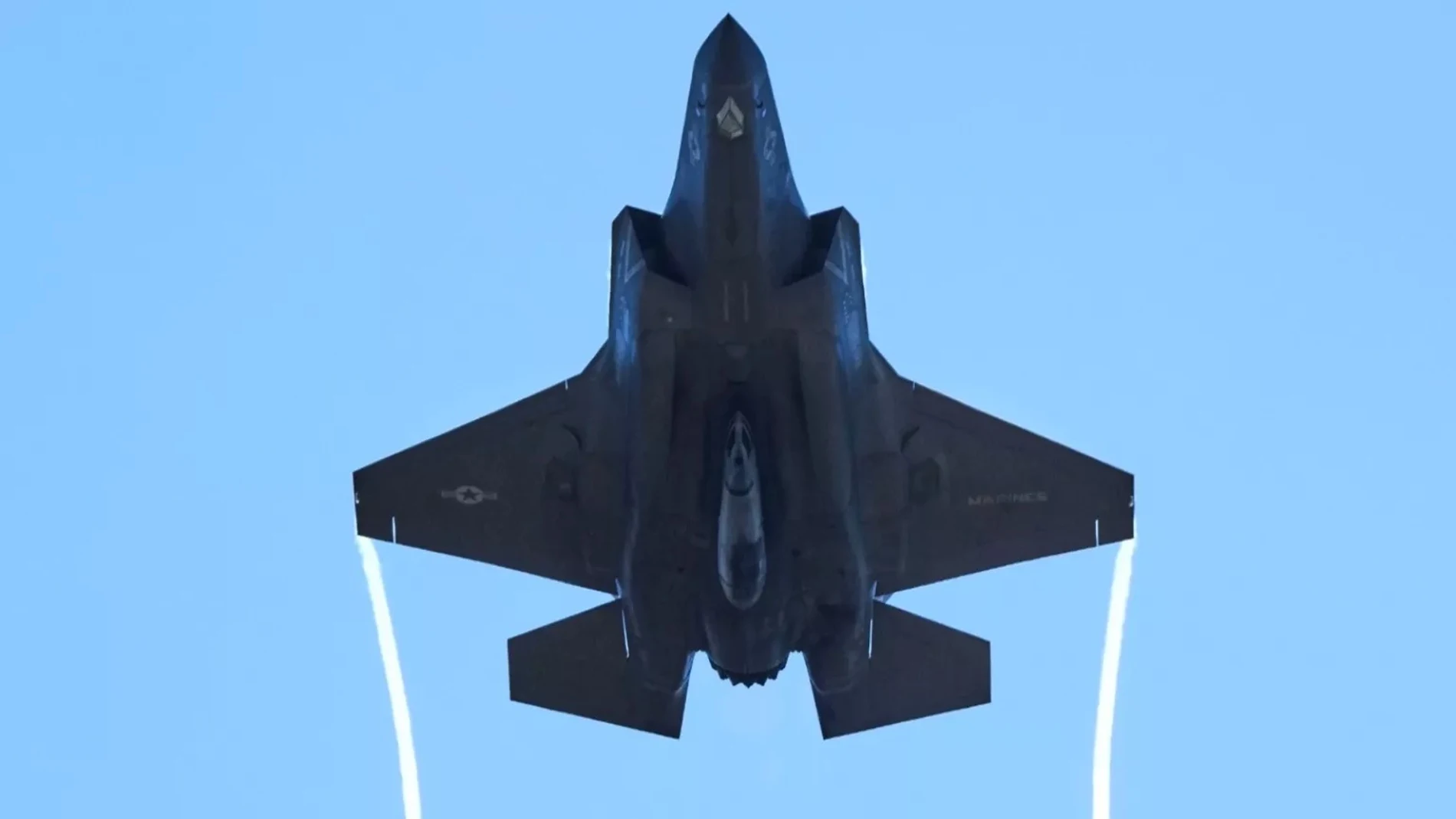 Aparece un avión de combate visto desde abajo, por lo que podemos verle la "barriga"