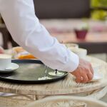 Camarero recogiendo una mesa en un restaurante