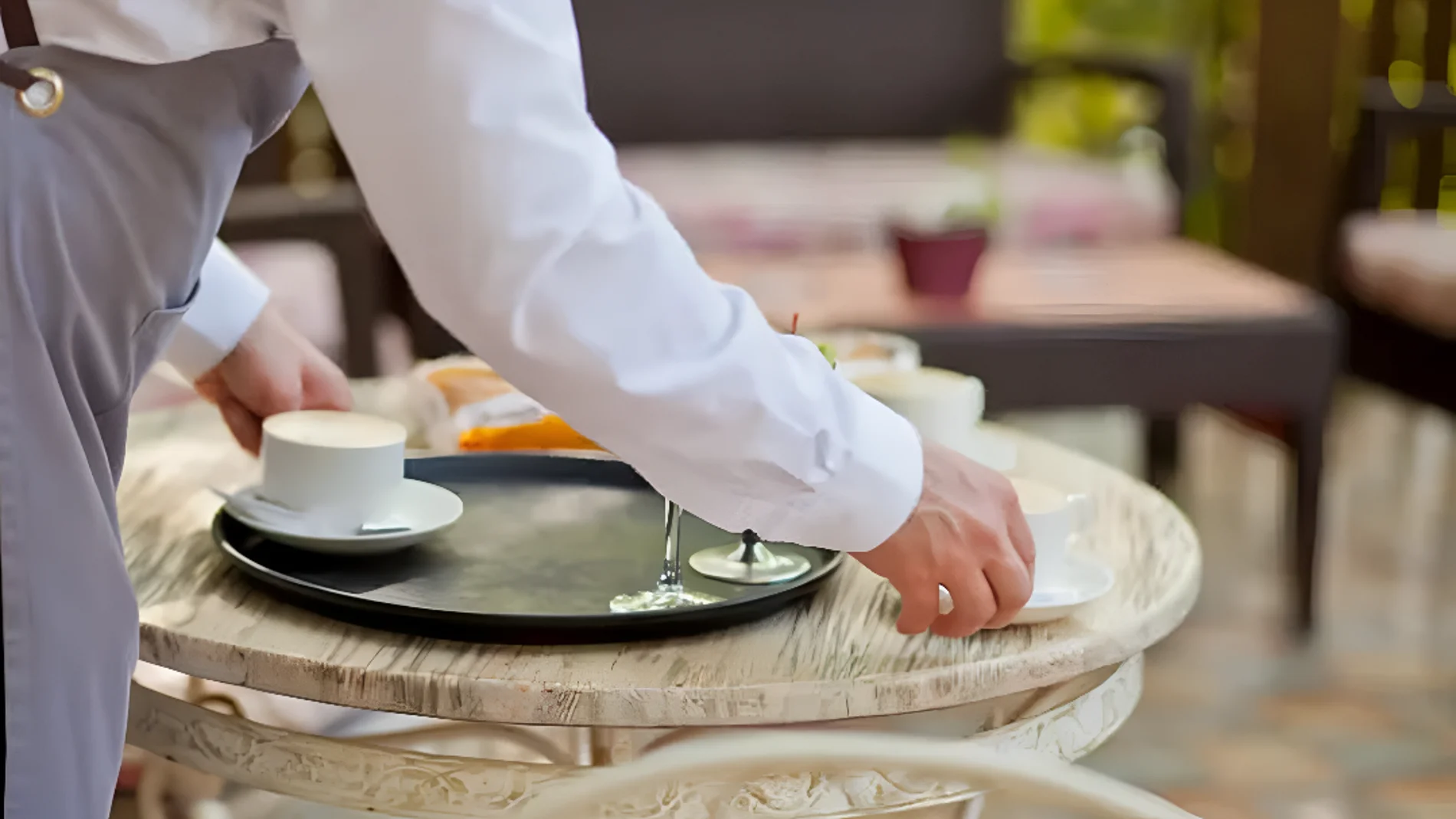 Camarero recogiendo una mesa en un restaurante