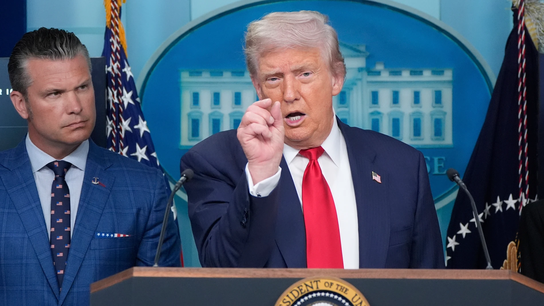 President Donald Trump speaks with reporters in the James Brady Press Briefing Room at the White House, Monday, Aug. 11, 2025, in Washington, as Secretary of Defense Pete Hegseth looks on. (AP Photo/Alex Brandon)