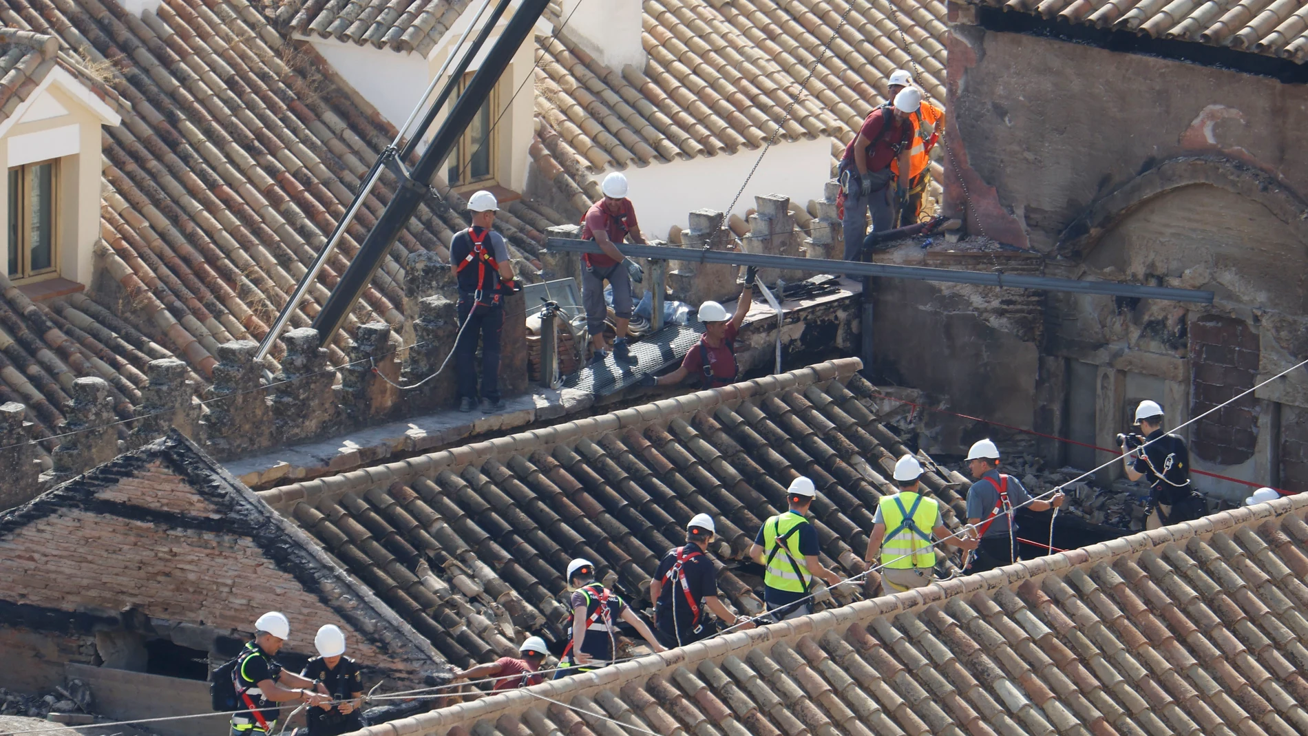 CÓRDOBA, 11/08/2025.- Operarios trabajan en la zona afectada en las cubiertas de la Mezquita-Catedral de Córdoba, sobre todo en el techo de la capilla de la Anunciación, que fue la que colapsó a causa del incendio declarado el pasado viernes en una de las capillas, este lunes en el que la Unidad de Policía Científica de la Policía Nacional junto a los arquitectos y técnicos están inspeccionando los daños sufridos en el monumento. EFE/Salas