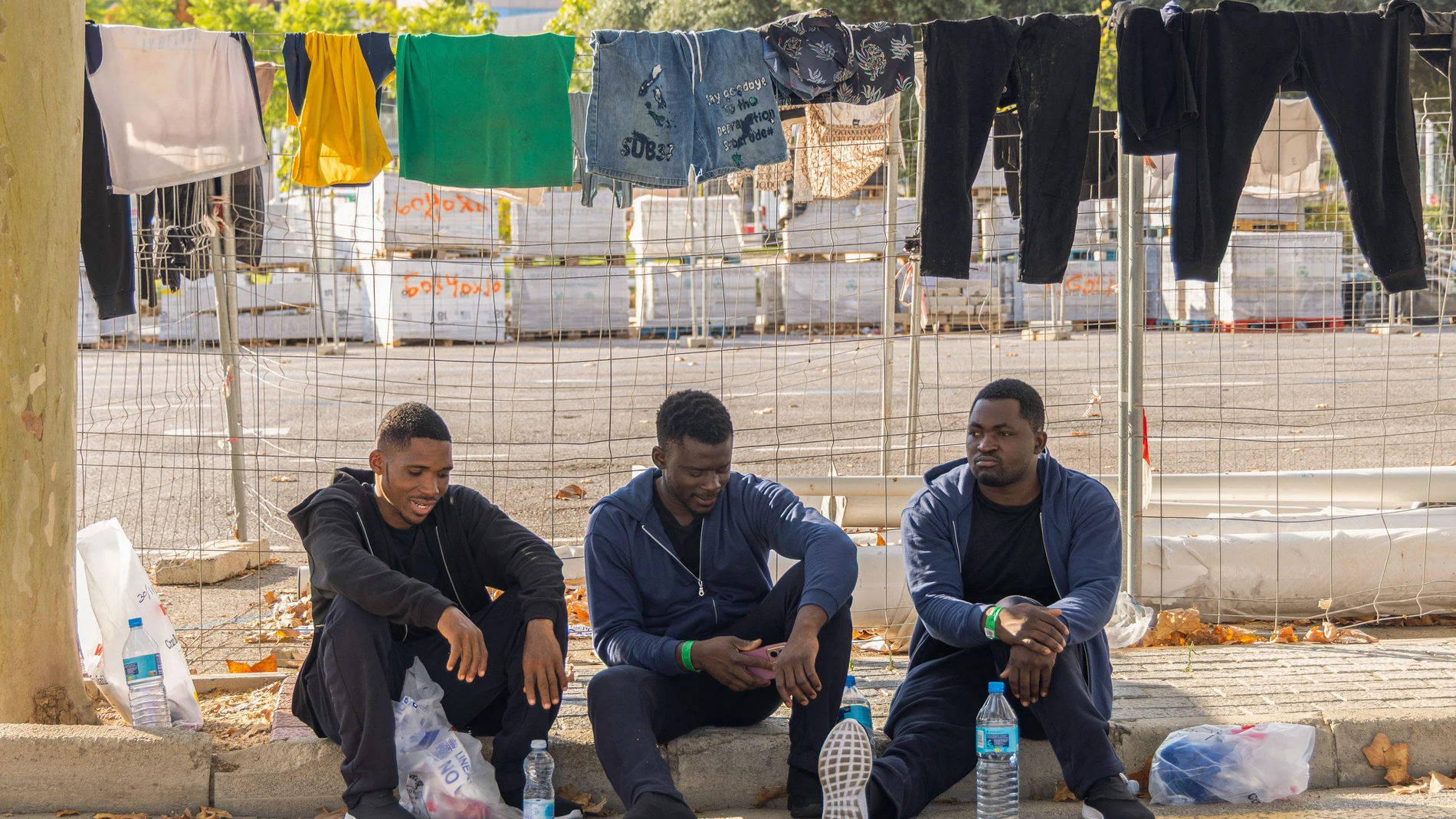 PALMA , 13/08/2025.- Unos migrantes, recién llegados a Baleares , esperan en la estación Marítima de Palma para viajar mañana a la Península. Agentes del servicio marítimo de la Guardia Civil y Salvamento Marítimo han interceptado esta mañana a dos grupos con un total de 43 inmigrantes llegados en dos pateras distintas a Cabrera, con lo que ascienden a 237 las personas arribadas a Baleares este miércoles en quince embarcaciones. EFE/CATI CLADERA