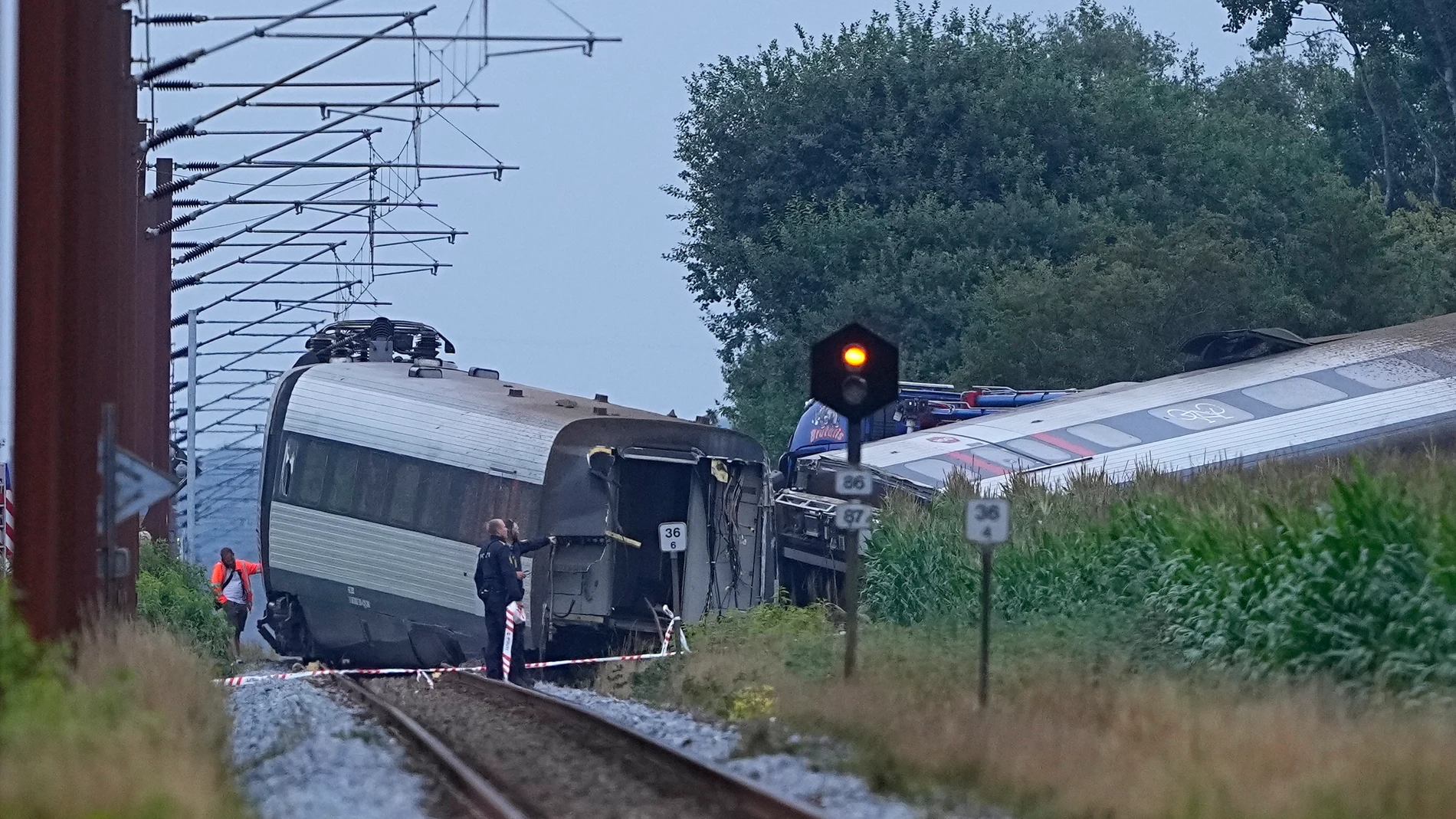 Emergency services attend the passenger train derailment at the village of Bjerndrup between Kliplev and Tinglev in Southern Jutland, Denmark, Friday Aug. 15, 2025. (Bo Amstrup/Ritzau Scanpix via AP)
