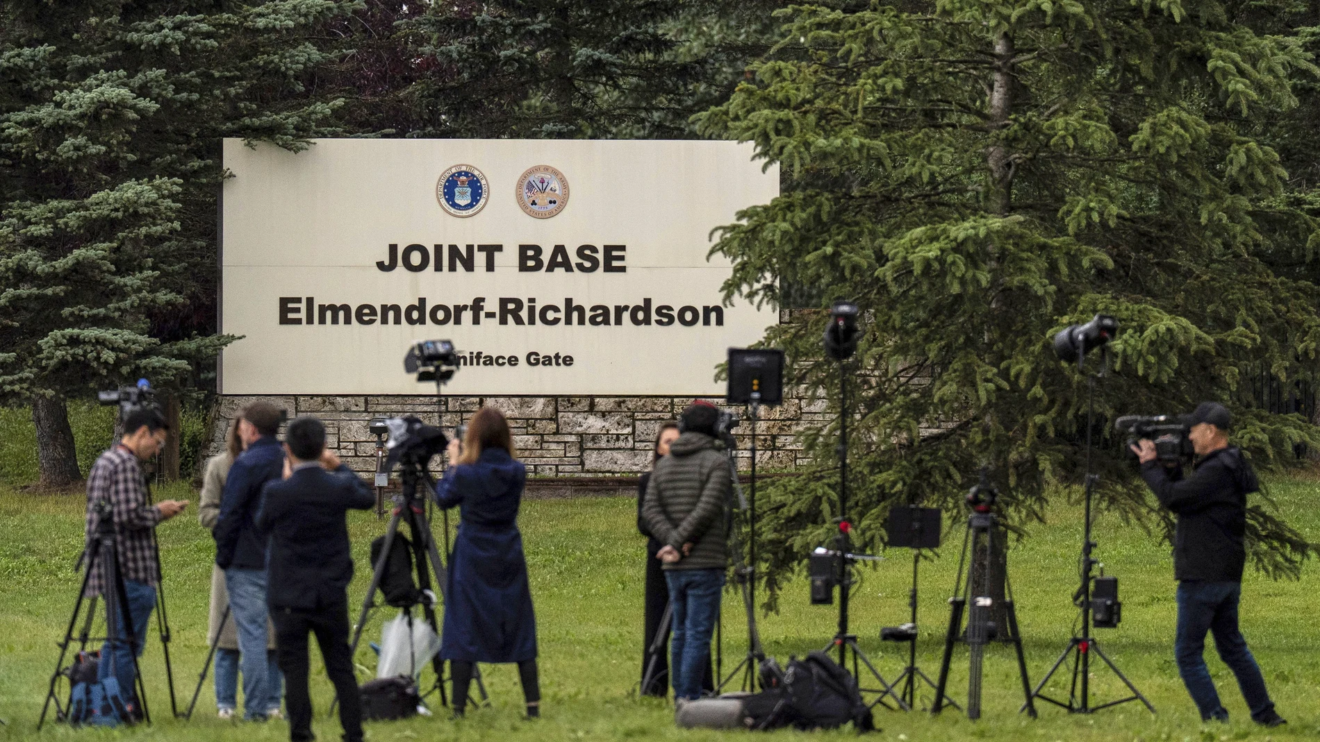 Members of the media stand outside Joint Base Elmendorf-Richardson in Anchorage, Alaska, Thursday, Aug. 14, 2025, ahead of a meeting between President Donald Trump and Russia's President Vladimir Putin.