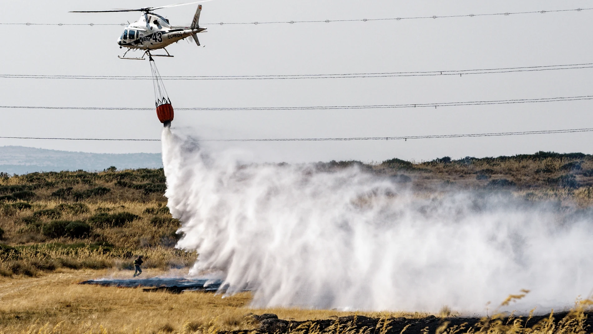ÁVILA (CASTILLA Y LEÓN), 15/08/2025.- Un helicóptero trabaja este viernes, en labores de extinción del incendio en las proximidades de Urraca-Miguel, barrio anexionado de Ávila capital, y cuyos vecinos han sido evacuados pasadas las 16 horas por la proximidad de las llamas. EFE/ Raúl Sanchidrián