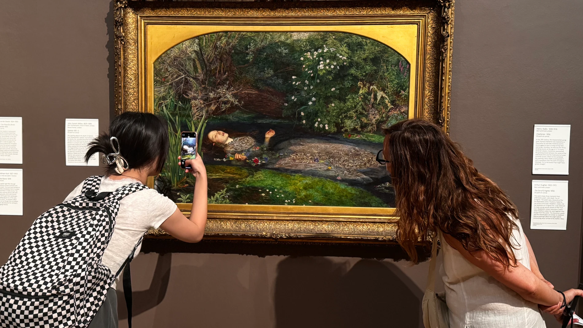LONDRES, 16/08/2025.- Dos mujeres observan la Ofelia, de John Everett Millais, en la Tate Britain, cuadro en el que se inspira la portada del disco. En 'The Life of a Showgirl', el nuevo álbum de Taylor Swift, la cantante se convierte en Ofelia, personaje del 'Hamlet' de William Shakespeare, recreando en la portada la trágica escena de su muerte, dedicándole uno de los temas y profundizando en su enigmático vínculo creativo con el dramaturgo inglés. EFE/ Raúl Bobé