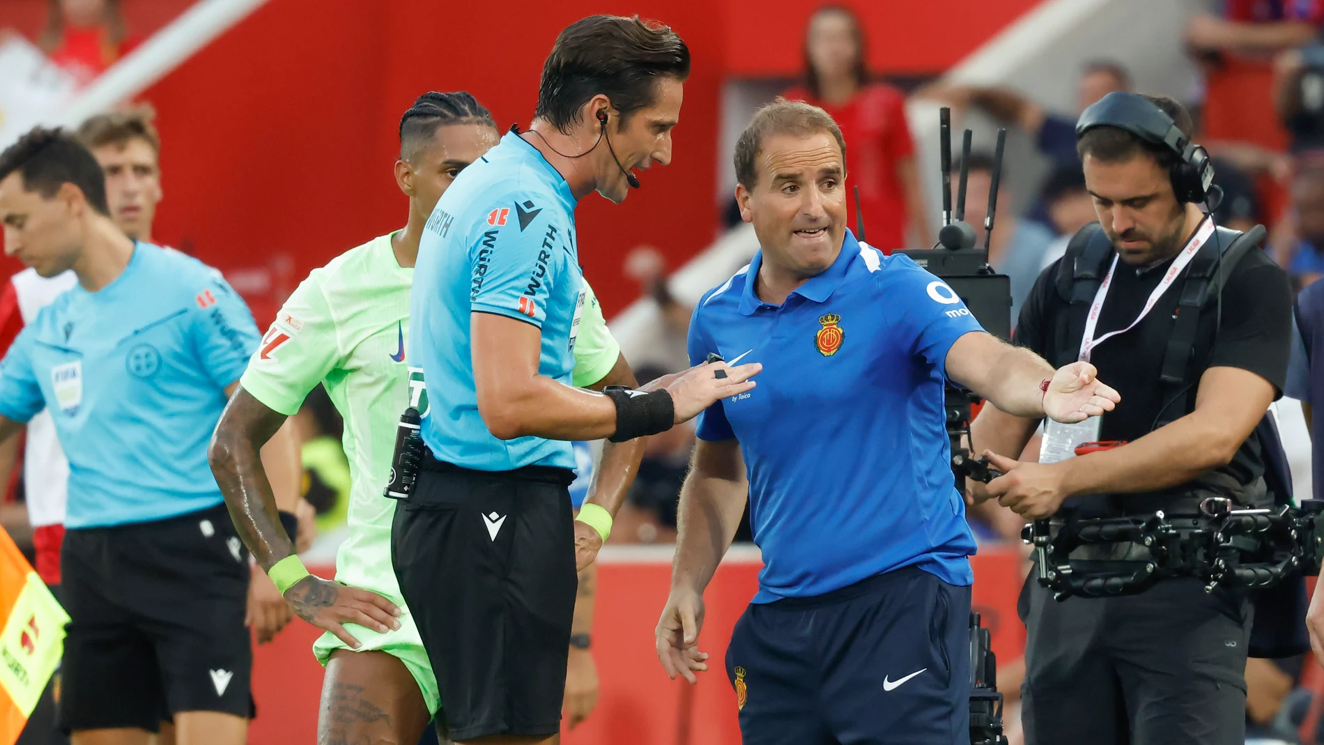 PALMA DE MALLORCA, 16/08/2025.- El árbitro del encuentro José Luis Munuera (c) conversa con el entrenador del Mallorca, Jagoba Arrasate (2d), tras el segundo gol del Barcelona este sábado, durante la primera jornada de LaLiga EA Sports, entre el RCD Mallorca y el FC Barcelona, en el estadio de Son Moix de Palma de Mallorca. EFE/ Cati Cladera