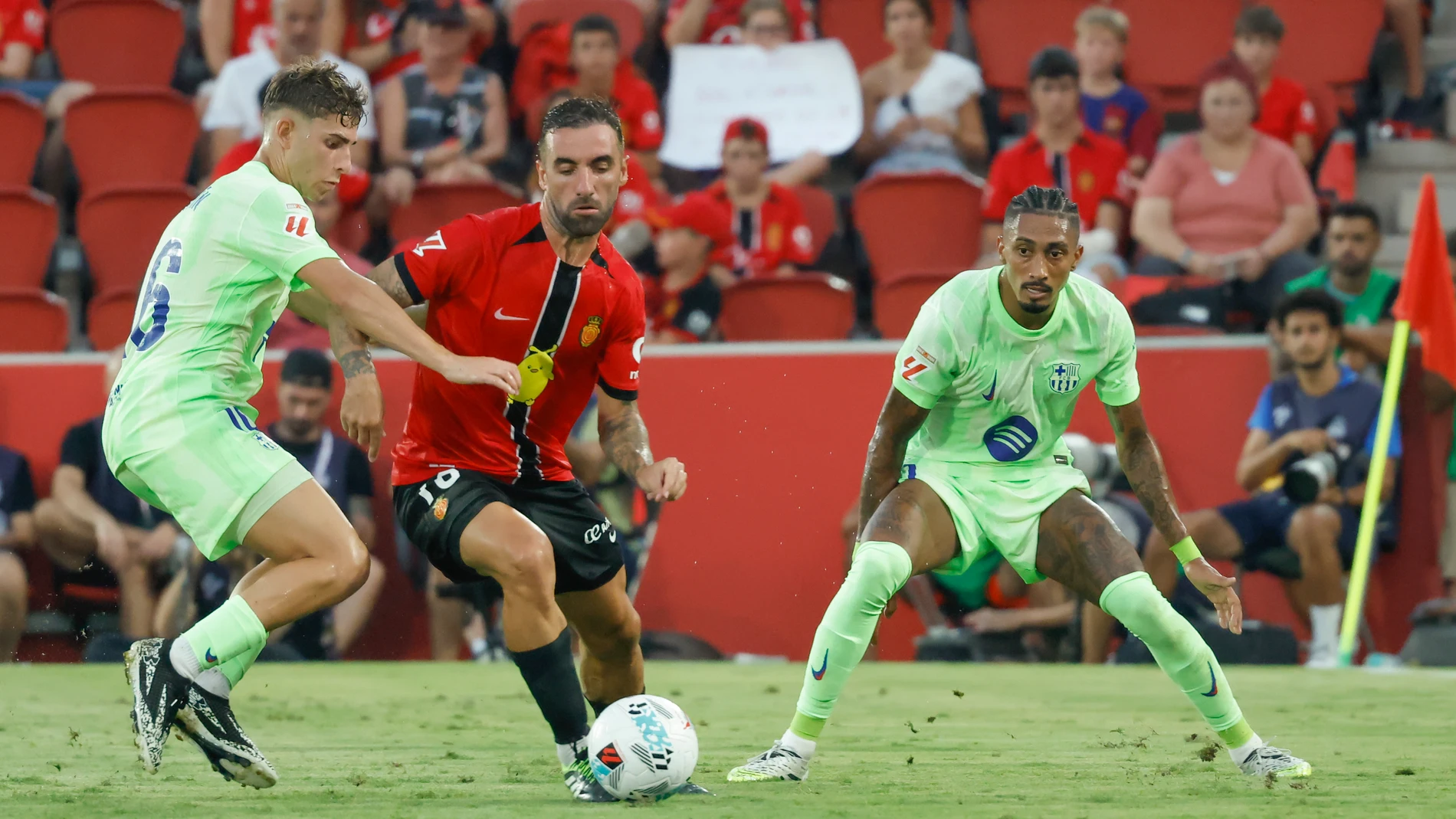 PALMA DE MALLORCA, 16/08/2025.- El centrocampista del Mallorca Sergi Darder (c) pelea un balón ante Fermín López (i) y Raphinha del Barcelona este sábado, durante la primera jornada de LaLiga EA Sports, entre el RCD Mallorca y el FC Barcelona, en el estadio de Son Moix de Palma de Mallorca. EFE/ Cati Cladera