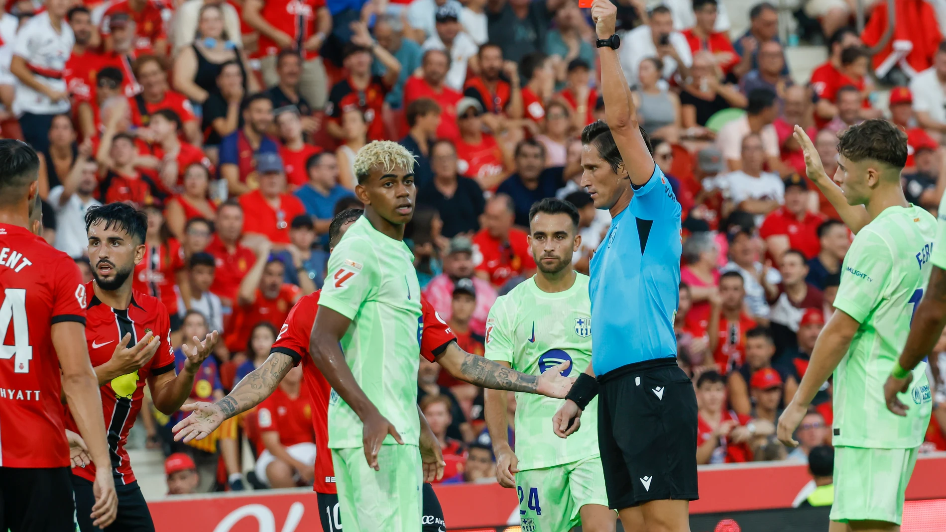 PALMA DE MALLORCA, 16/08/2025.- El árbitro del encuentro José Luis Munuera (d) saca tarjeta roja a Manu Morlanes (i) del Mallorca este sábado, durante la primera jornada de LaLiga EA Sports, entre el RCD Mallorca y el FC Barcelona, en el estadio de Son Moix de Palma de Mallorca. EFE/ Cati Cladera