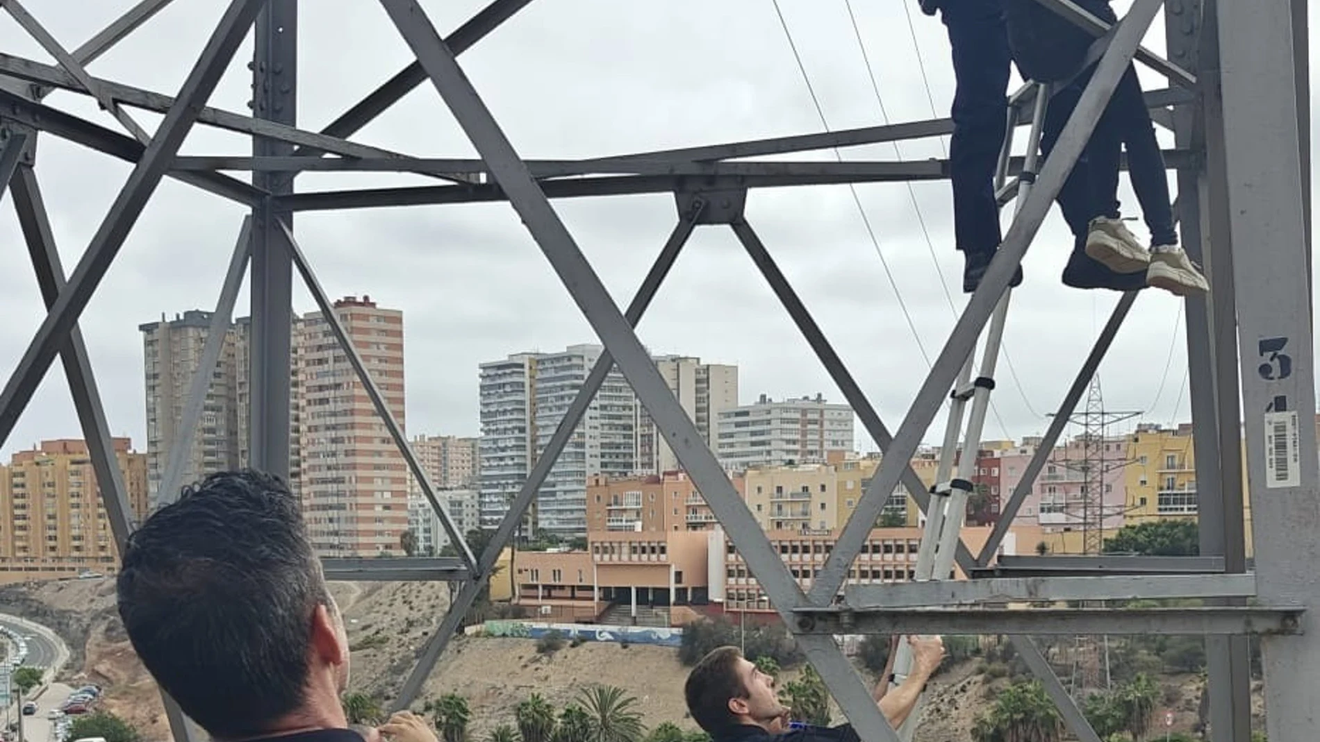 Momento en que la mujer se encarama a una torre eléctrica