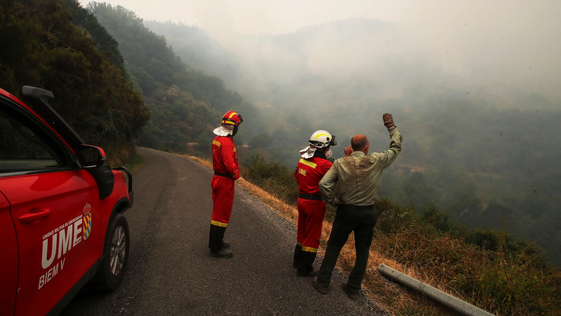 PONFERRADA, 18/08/2025.-Vecinos de la zona esperan ordenes de La UME para bajar a refrescar la zona e impedir el avance del fuego hacia Santo tirso en la carretera desde Santo Tirso de Cabarcos a Oencia en Ponferrada, León, este lunes. Durante los últimos días, los bomberos han centrado sus esfuerzos en proteger Compludo, aunque también han trabajado en Bouzas y Oencia, donde la resistencia a la evacuación obligó a actuaciones de urgencia. EFE/ Ana F. Barredo