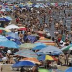 Miles de bañistas disfrutan del sol y el mar en las playas de Las Arenas y la Malvarrosa de Valencia. 