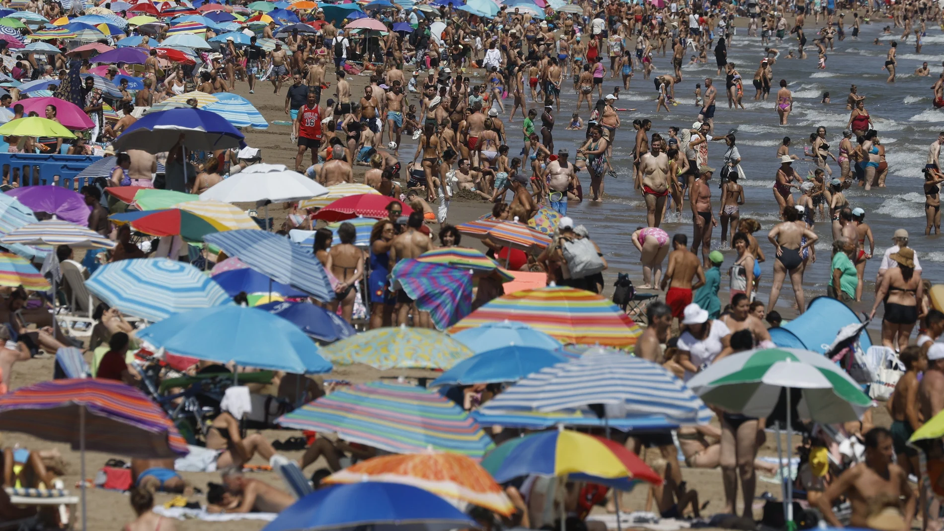 Miles de bañistas disfrutan del sol y el mar en las playas de Las Arenas y la Malvarrosa de Valencia.