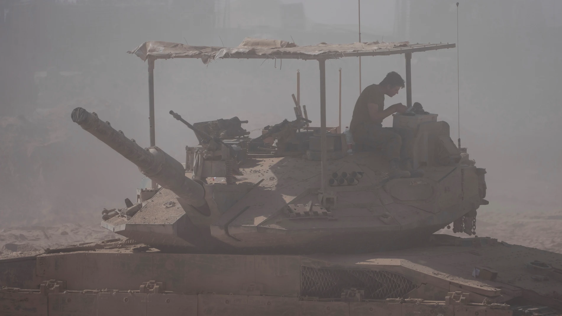 An Israeli soldier sits on the top of a tank parked on an area near the Israeli-Gaza border, as seen from southern Israel, Wednesday, Aug. 20, 2025. (AP Photo/Maya Levin)