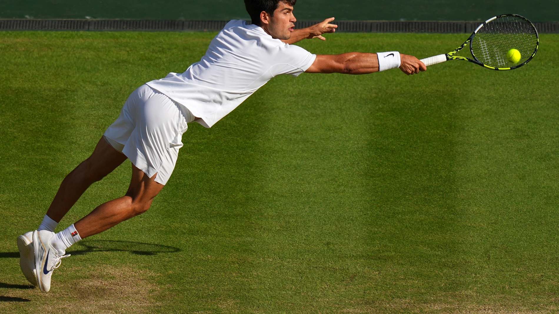 FILE - Carlos Alcaraz, of Spain, returns to Italy's Jannik Sinner in the men's singles final at the Wimbledon Tennis Championships in London, July 13, 2025. (AP Photo/Joanna Chan, File)