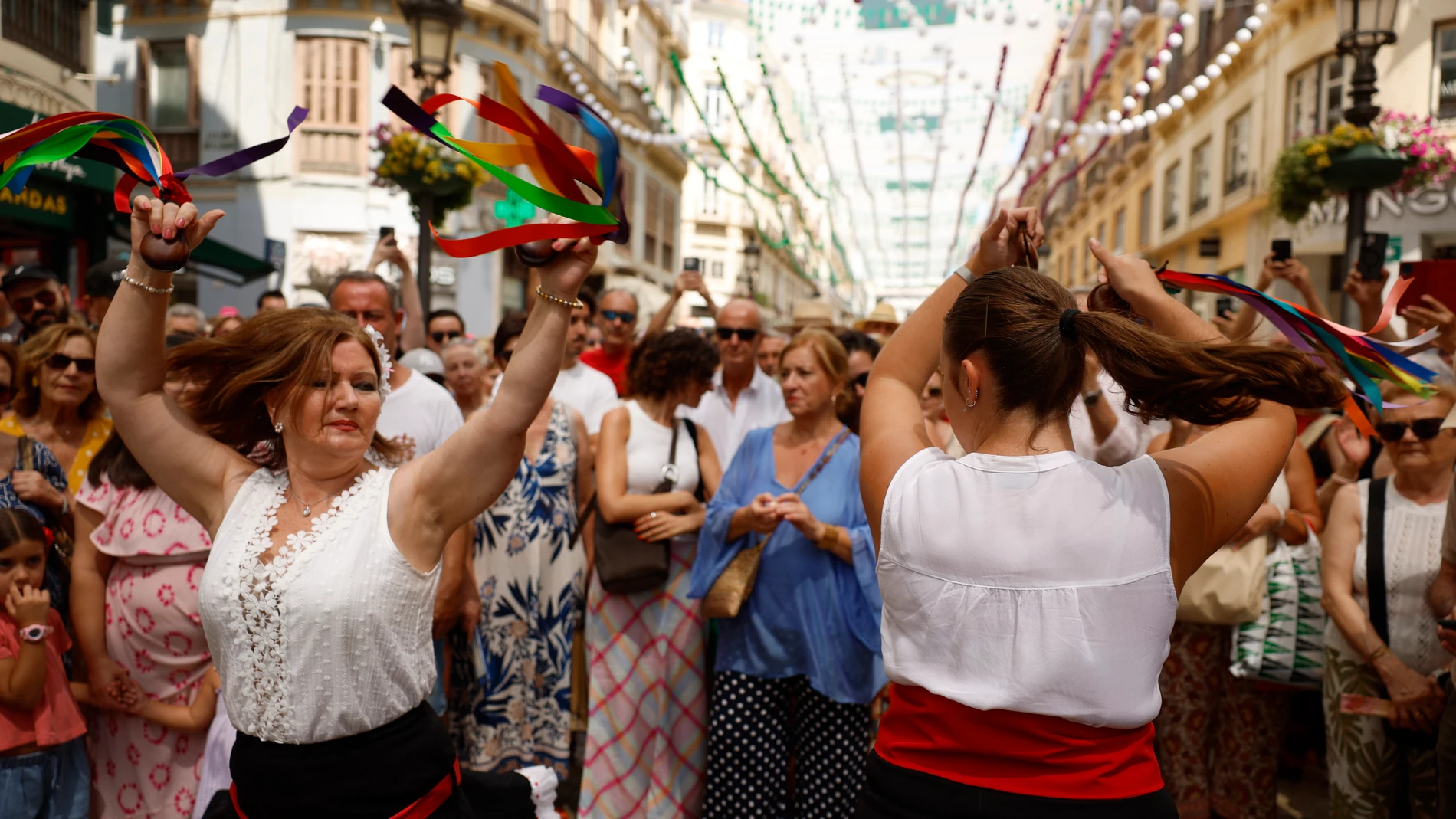 MÁLAGA, 21/08/2025.- Mujeres de un grupo de verdiales bailan este jueves en la feria del centro de Málaga. EFE/Jorge Zapata