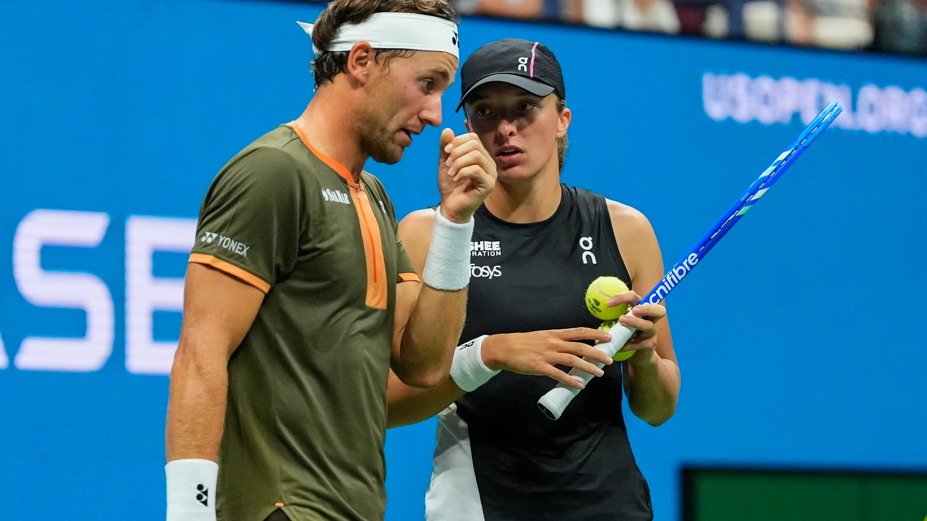 Casper Ruud, left, of Norway, talks with Iga Swiatek, right, of Poland, during the mixed doubles semi final at the U.S. Open tennis championships, Wednesday, Aug. 20, 2025, in New York. (AP Photo/Yuki Iwamura)