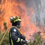 Un bombero trata de controlar el fuego cerca de Mougás (Pontevedra)