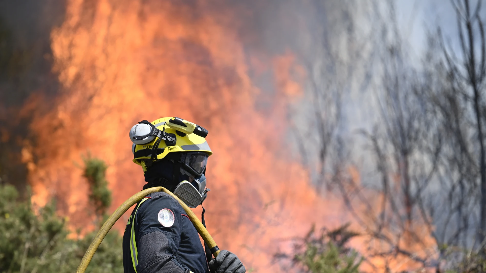 Un bombero trata de controlar el fuego cerca de Mougás (Pontevedra)