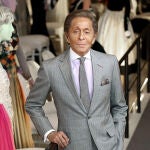 El diseñador de moda Valentino Garavani que posa con uno de sus diseños dentro de la exposición "Valentino: Maestro de la Alta Costura",