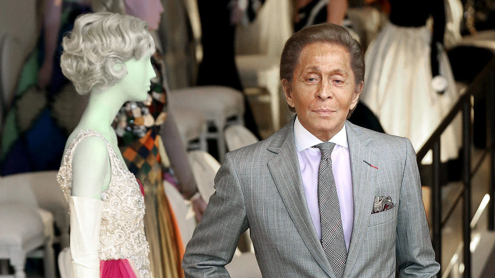 El diseñador de moda Valentino Garavani que posa con uno de sus diseños dentro de la exposición "Valentino: Maestro de la Alta Costura",